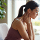woman holding her scalene muscles in her neck